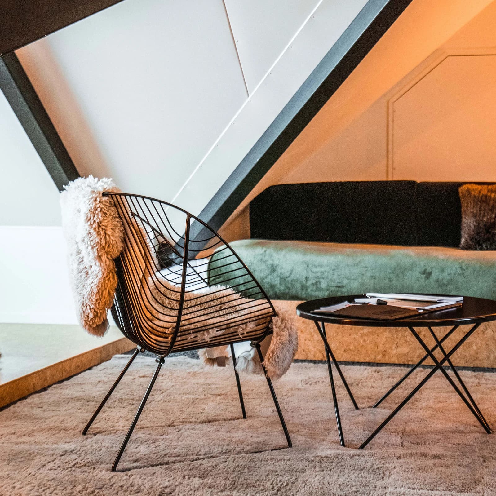 A modern studio apartment lounge area with arm chair, couch and coffee table.  