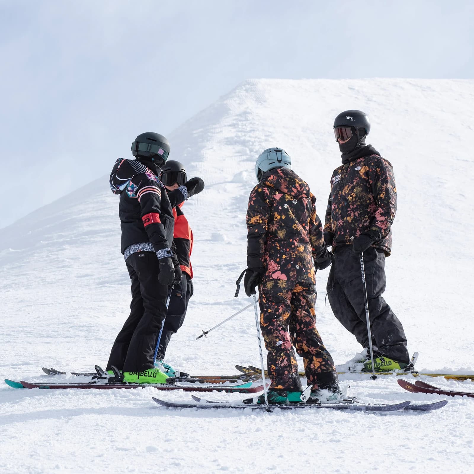 A group of skiers at Cardrona Alpine Resort listens attentively to their instructor, discussing the terrain and preparing for their next run down the slopes.