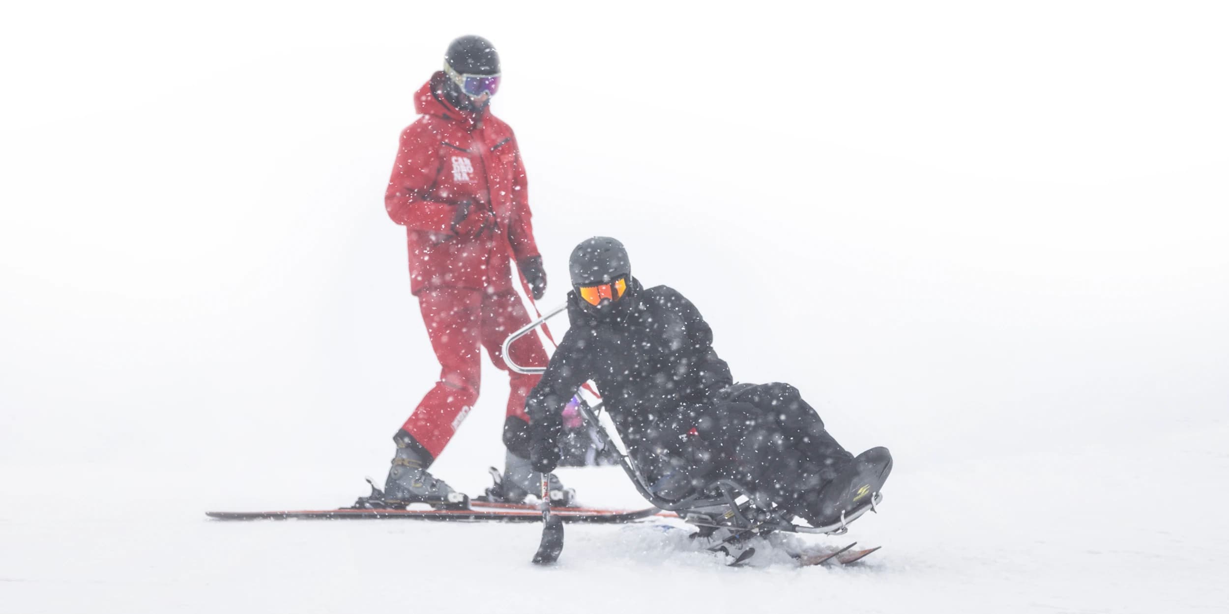 An adaptive skier uses their out rigger to turn whilst on a lesson at Cardrona.