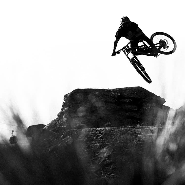 A person rides over a large jump at the Cardrona bike park.