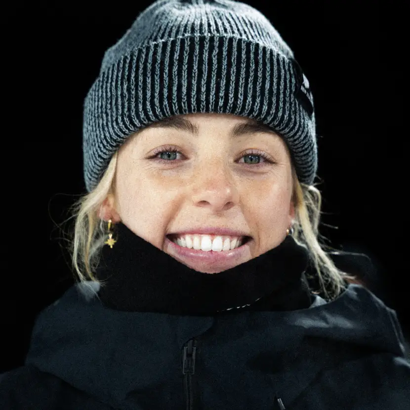 Headshot of NZ snowboarder Zoi Sadowski-Synnott wearing a NZ Olympic team beanie.
