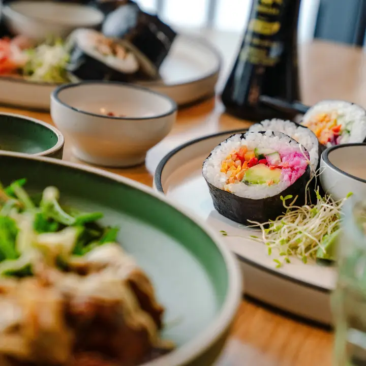Colourful sushi rolls and Asian-style dishes served at a table.