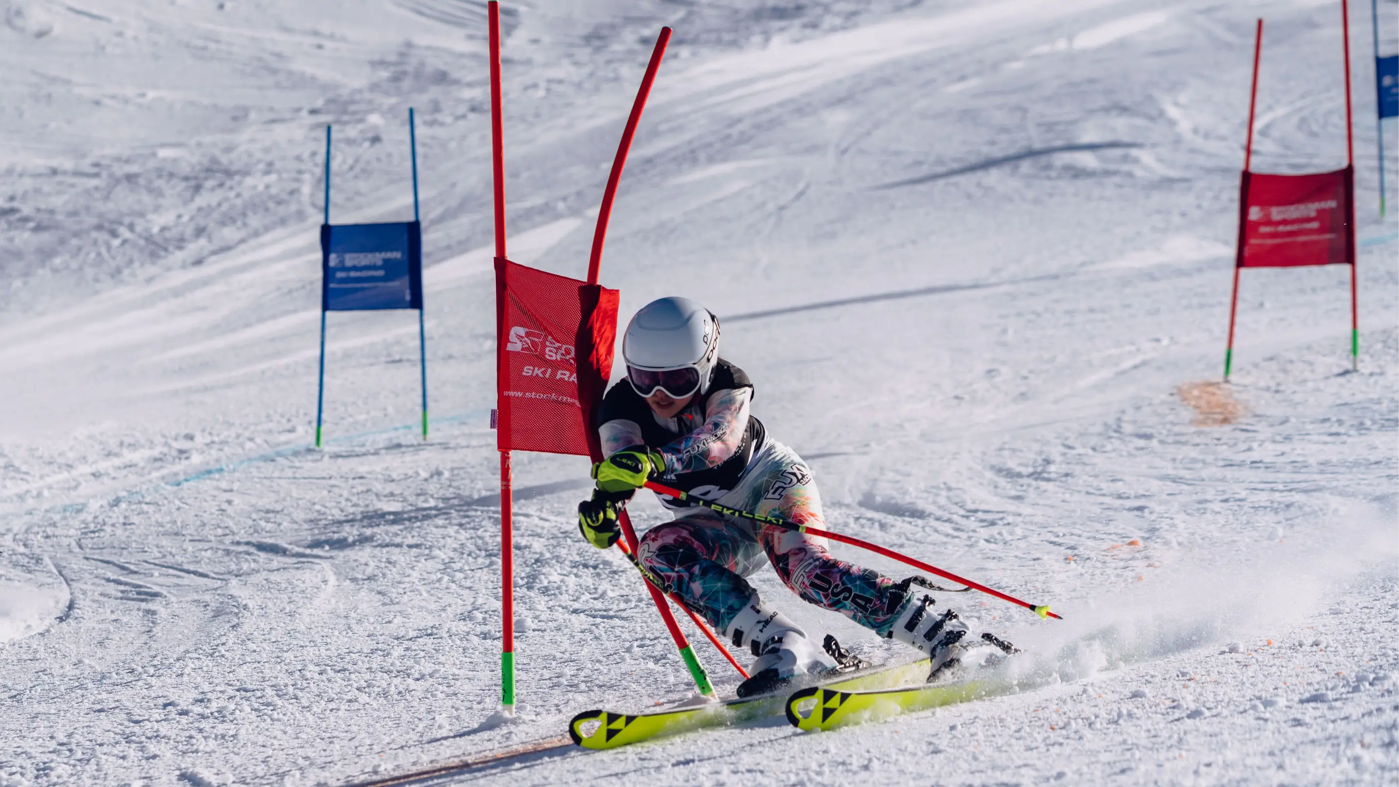 A competitive skier carving through a slalom gate during a race at Cardrona Alpine Resort.