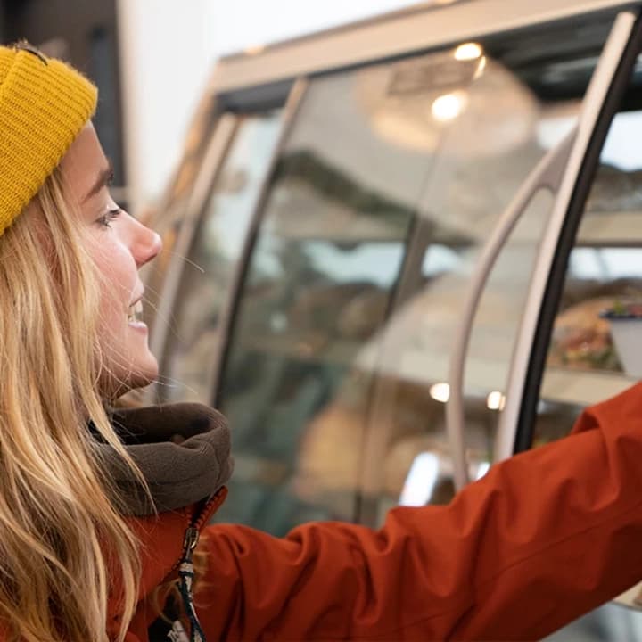 A lady selects food from a range of cabinet at Cardrona.