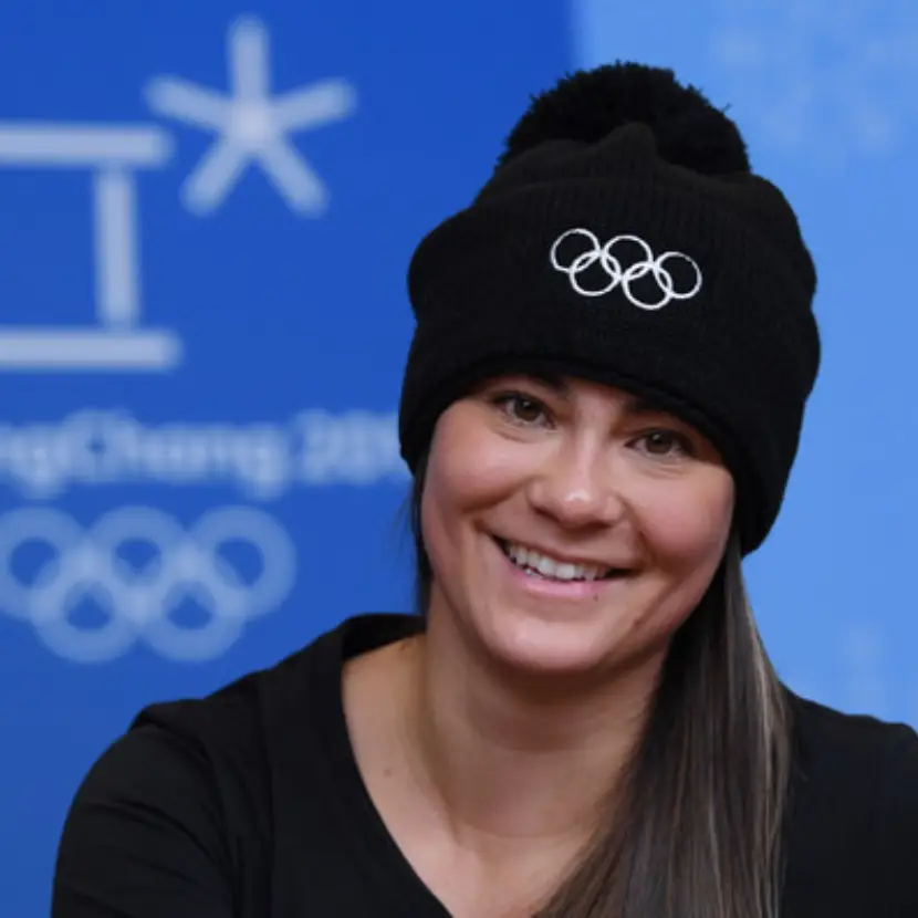 Headshot of New Zealand freestyle skier, Janina Kuzma, wearing a black beanie with the Olympic rings logo on the front.
