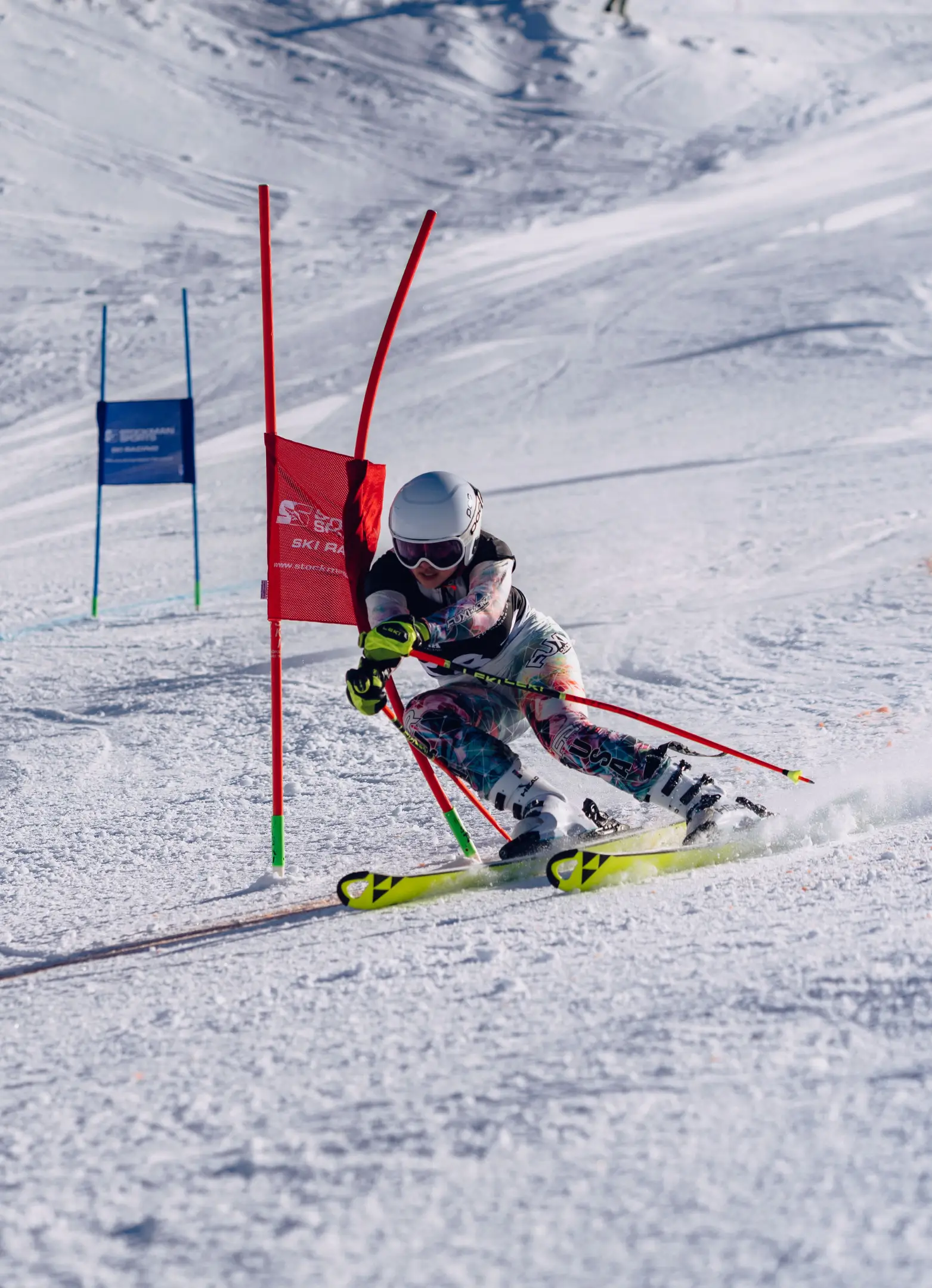 A competitive skier carving through a slalom gate during a race at Cardrona Alpine Resort.